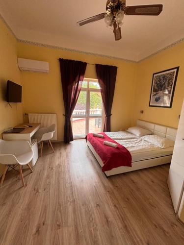 a bedroom with a bed and a desk and a table at Y Panzió in Balatonlelle
