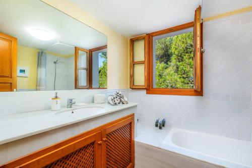 a bathroom with a sink and a large mirror at Cala Pi One in Cala Pi