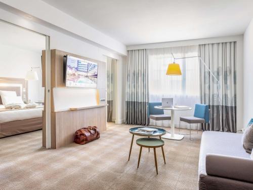 a hotel room with a couch and a table at Novotel Lugano Paradiso in Lugano