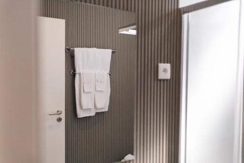 a bathroom with white towels hanging on a wall at Quinta da Portela Douro in Armamar