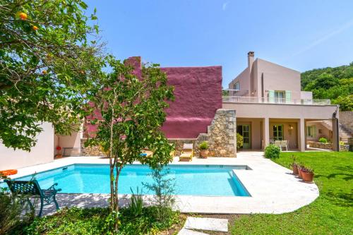 a house with a swimming pool in the yard at Villa Verde Petra in Rethymno
