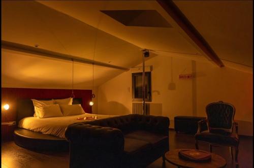 a bedroom with a bed and a couch and a chair at Ruelle Sensuelle in Ruelle-sur-Touvre