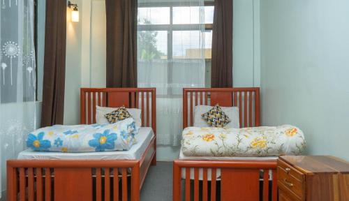 two chairs with pillows in a room with a window at Eva Residence Arusha in Arusha