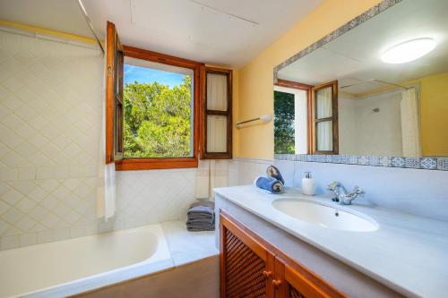 a bathroom with a sink and a tub and a mirror at Cala Pi Two in Cala Pi