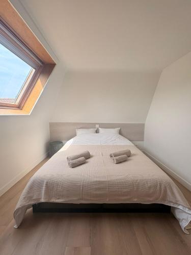 a bedroom with a bed with two towels on it at Maison Lavandelle in Middelkerke