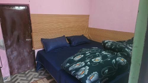 a bedroom with a bed with a blue comforter at Dakshu guest house in Ukhimath