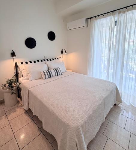 a white bed in a bedroom with a window at Selini Apartments Mani in Agios Nikolaos