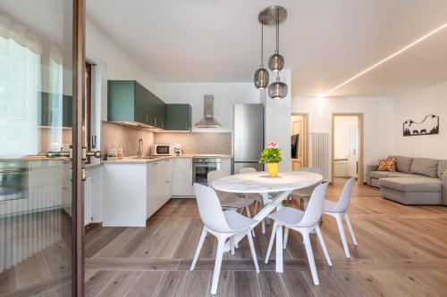 a kitchen and dining room with a white table and chairs at Maison Bovet Appartements in Arvier