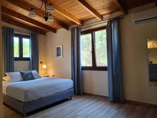 a bedroom with a bed and two windows at Terra Solaris Guesthouse in Kissamos