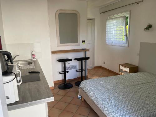 a bedroom with a bed and two bar stools at Gîtes de La Ferme De Kereven in Bénodet