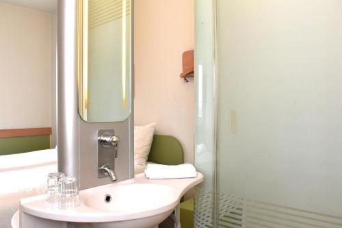 a bathroom with a sink and a mirror at ibis Budget Luxembourg Sud in Livange