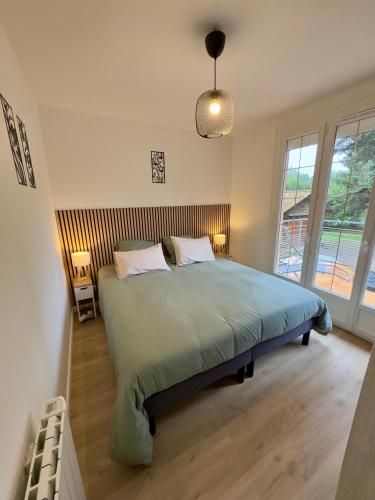 a bedroom with a large bed with two pillows at Gîte Chez Armande in Surfonds