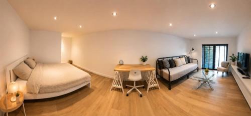 a bedroom with a bed and a table and a couch at B&B The Parklane Retreat in Schoten
