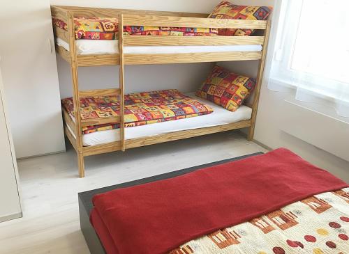 a room with two bunk beds with a red rug at Szende Apartman in Balatonfüred