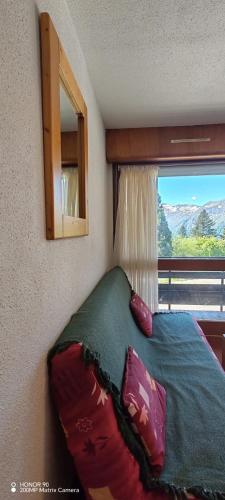a bedroom with a bed with a mirror and a window at L'Ancien Temps in Ustou