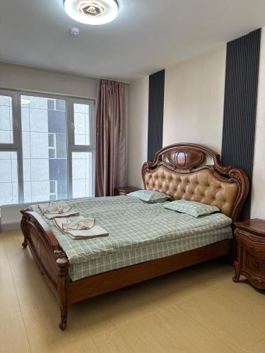 a bedroom with a large bed with a wooden headboard at Newly built Modern 2 BR apartment in Ulaanbaatar