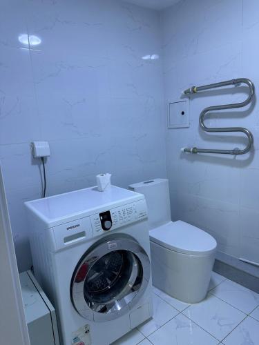 a bathroom with a washing machine and a toilet at Newly built Modern 2 BR apartment in Ulaanbaatar