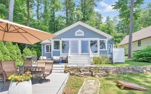 a blue cottage with a deck with a table and chairs at Lakeside Haven, Tranquil Waters in Holland