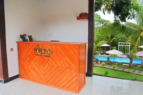 a wooden gate in a room with a view of a pool at Mamaras Guest House in Nusa Penida