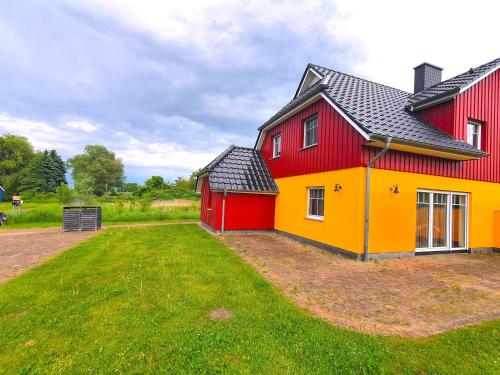 ein rot-gelbes Haus mit einem Garten in der Unterkunft Rood Huus in Dabitz