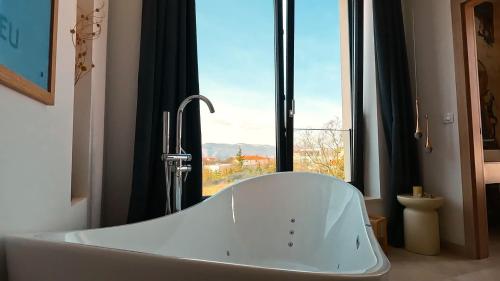 a bath tub in a bathroom with a window at Villa Elementa Krk - Luxury Four Elements Experience in Krk