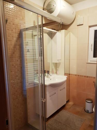 a bathroom with a white sink and a shower at Vicko villa in Seget Vranjica