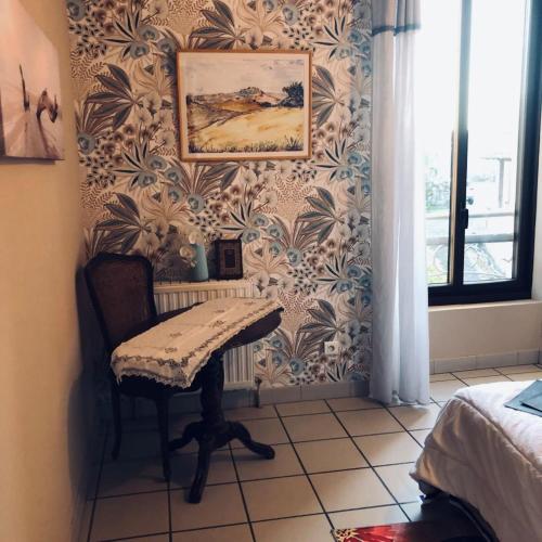 a room with a table and a picture on the wall at ROMELLA's ROOM FAMILY in Saint-Projet