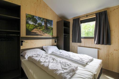 a bedroom with two beds and a window at Nieuw!! Chalet De Luxe 4 persoons met airco in Oorsbeek