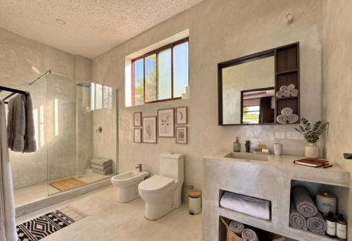 a bathroom with a toilet and a sink and a shower at Casa Samara in Diani Beach