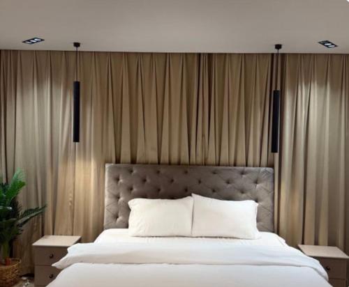 a bedroom with a large white bed with curtains at نزل بسمة الأبداع in Abha