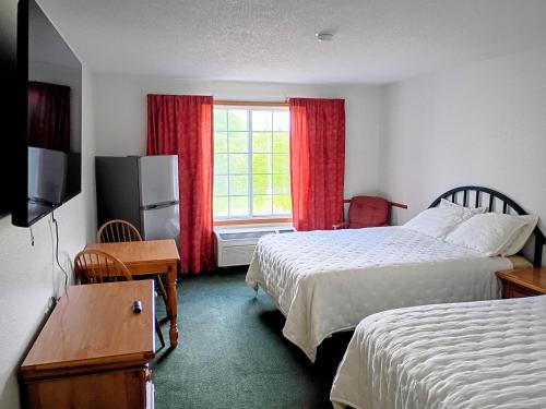a hotel room with two beds and a window at Garrison Inn and Suites in Garrison