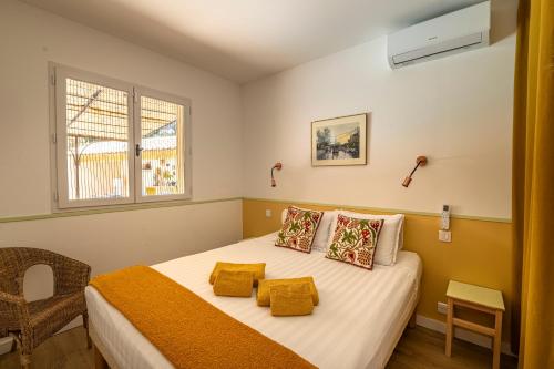 a bedroom with a bed with yellow pillows at Villa la Rabassa in Lauris
