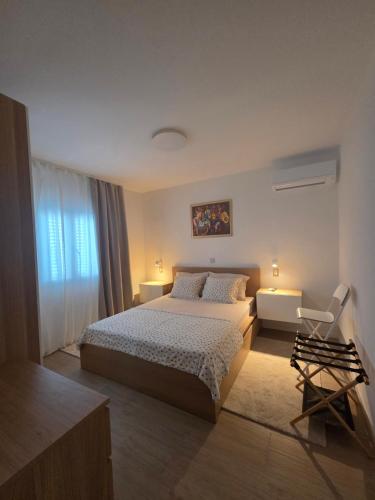 a bedroom with a large bed and a window at Apartmani ANCORA, Crkvice in Kuna Pelješka