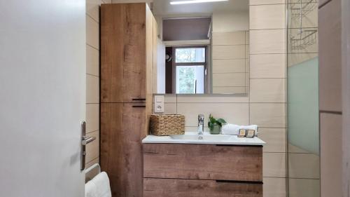 a bathroom with a sink and a mirror at AGENCE MOMENT'APART Legend in Mouvaux