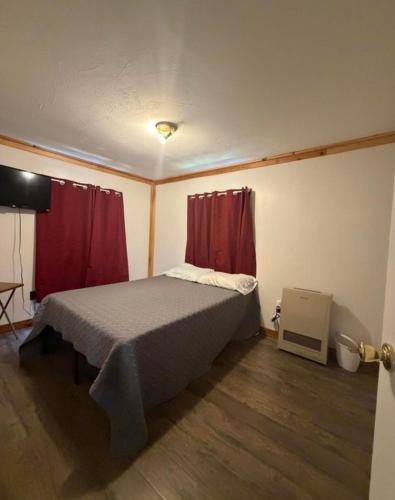 a bedroom with a bed with red curtains at Leapin leanas in Monson