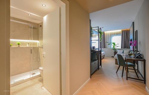 a bathroom with a shower and a table in a room at CP Hotels - Central in Milan