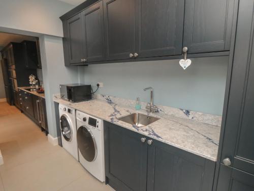 a kitchen with a sink and a washing machine at Ruby's Retreat in Filey