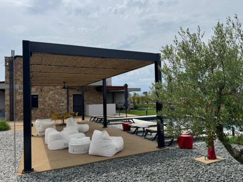 a pavilion with white chairs and tables in a yard at Sani e belli, Villas with private pool in Sani Beach