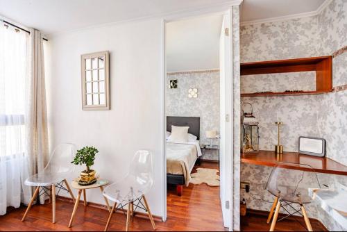 a room with a bed and a table and chairs at Lupe&Lulu aparments in Santiago