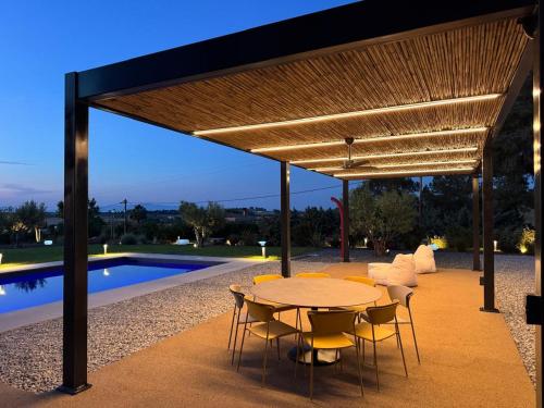 a table and chairs under a pavilion next to a pool at Sani e belli, Villas with private pool in Sani Beach