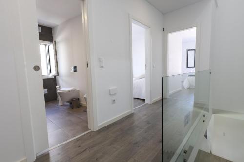 a white room with a toilet and a glass door at Villa Piscina Privada 3 Quartos 8 Hóspedes in Fernao Ferro