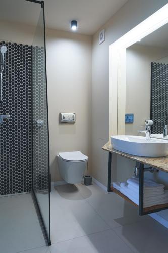 a bathroom with a sink and a toilet and a shower at Hotel Băile Bughea in Bughea de Sus