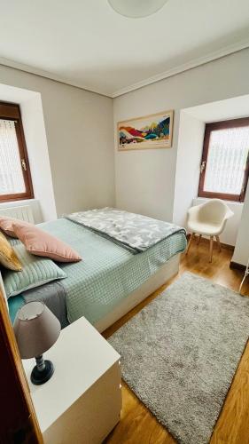 a bedroom with two beds and a table and a chair at Acogedor apartamento parque Aizkorri-Aratz a 45 min San Sebastian in Araya
