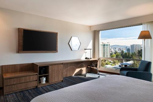 a hotel room with a bed and a television and a chair at Holiday Inn Express Quito by IHG in Quito
