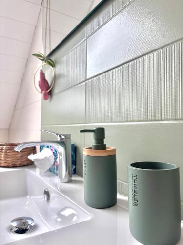 a bathroom sink with two cups on the counter at Lake View Balcony in Le Chenit