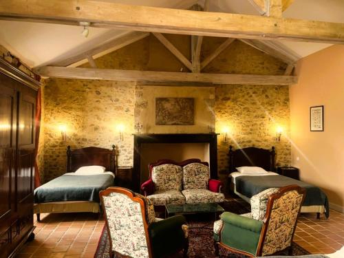 a bedroom with two beds and a chair at Logis Hôtel Le Boudoir in Belvès