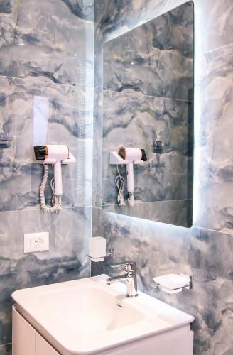 ein Badezimmer mit Waschbecken und Spiegel in der Unterkunft Hotel Kosova in Velipojë