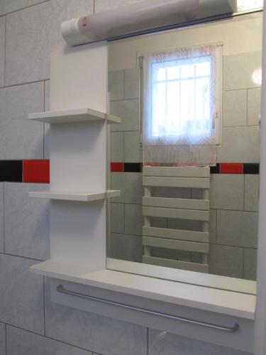 a mirror in a bathroom with a window at Residence Alassa in Montévrain