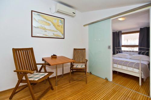 a room with a bed and a table and chairs at Apartment Plaza in Hvar