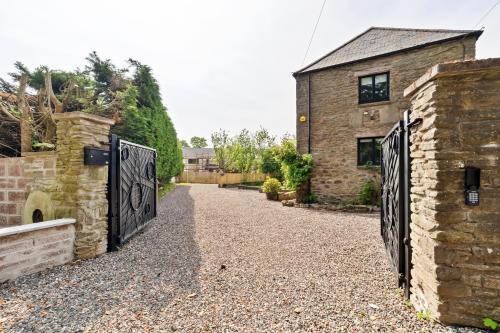 an external view of a stone house with a gate at Corn Flour Lodge - Pitkerro Mill in Dundee